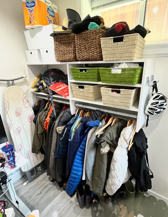 The second office before: a full coat rack, piled shoes and overflowing baskets on the wall